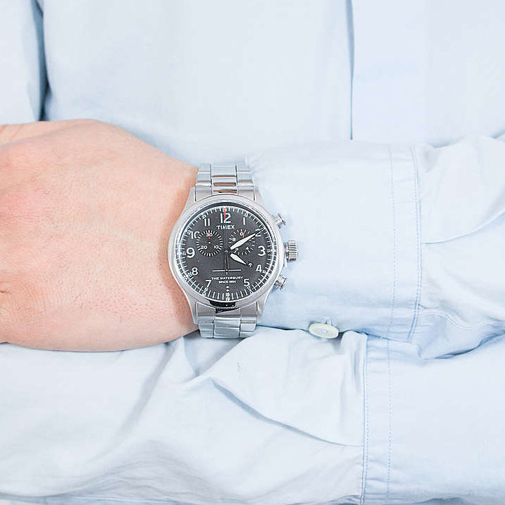 ساعة TIMEX Heritage Waterbury TW2R38400 - ساعة رجالية فضية من الفولاذ المقاوم للصدأ مع مينا أسود وإضاءة ليلية INDIGLO